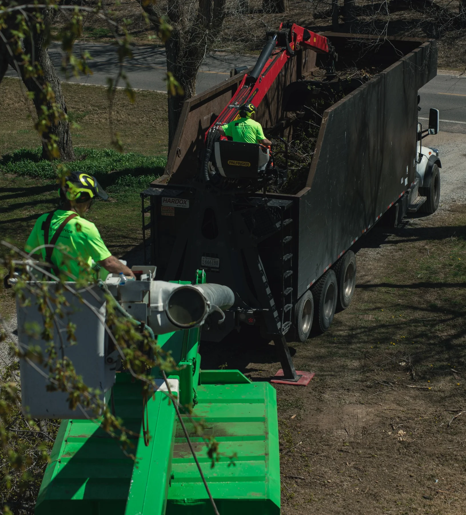 Grapple truck loading tree debris after storm cleanup